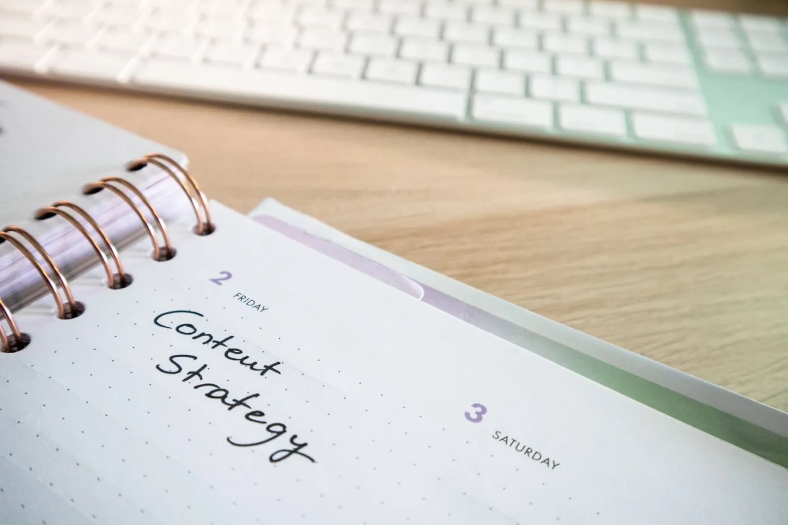 A content strategy plan handwritten in a notebook beside a keyboard